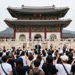 방탄소년단이 광화문 광장에서 공연하는 모습, 많은 관객이 무대를 응원하며 함께 노래하고 있다