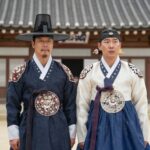 영화 왕과 사는 남자에서 박지훈이 연기한 단종과 유해진이 연기한 엄흥도가 청령포 배경 앞에 서 있는 장면