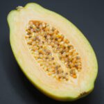 파파야메론을 반으로 갈라 속을 보여주는 사진, 부드러운 노란 과육과 씨가 보임