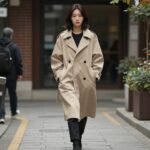 봄 가을 간절기 필수 여성 바바리 코트 숏 후드가 달린 베이지색 여성 바바리 코트를 입고 거리를 걷는 모습