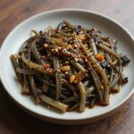 데친 오가피순을 국간장과 참기름으로 무친 나물 접시