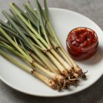 접시에 담긴 데친 땅두릅과 참두릅 나물, 옆에 초고추장이 함께 있음