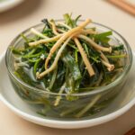 깨끗하게 씻어 썰어놓은 미나리와 콩나물이 투명한 국물에 담겨 있는 미나리 물김치