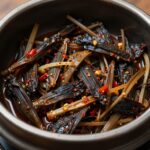 냄비에 담긴 명이나물 장아찌 절임장, 진한 색과 고추가 보임