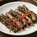 데치고 양념에 무친 구기자순나물이 접시에 담겨 있는 모습